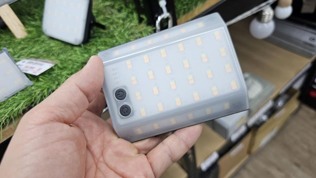 CLAYMORE 3Face Mini held in one hand to show its compact size and front LED panel