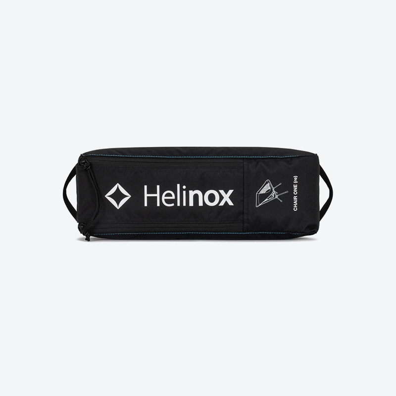 The packed Helinox Chair One RE inside its compact zippered carrying case, demonstrating its portable size.