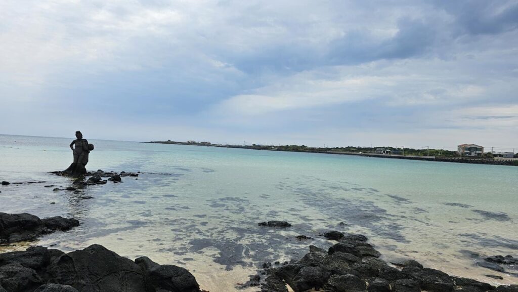 A serene view of the deep blue ocean horizon stretching out from a scenic coastal trail in Jeju Island.