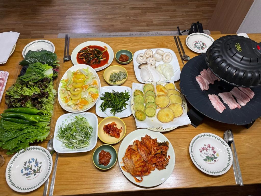Traditional Korean camping dinner prepared by K-papa with a cozy outdoor atmosphere