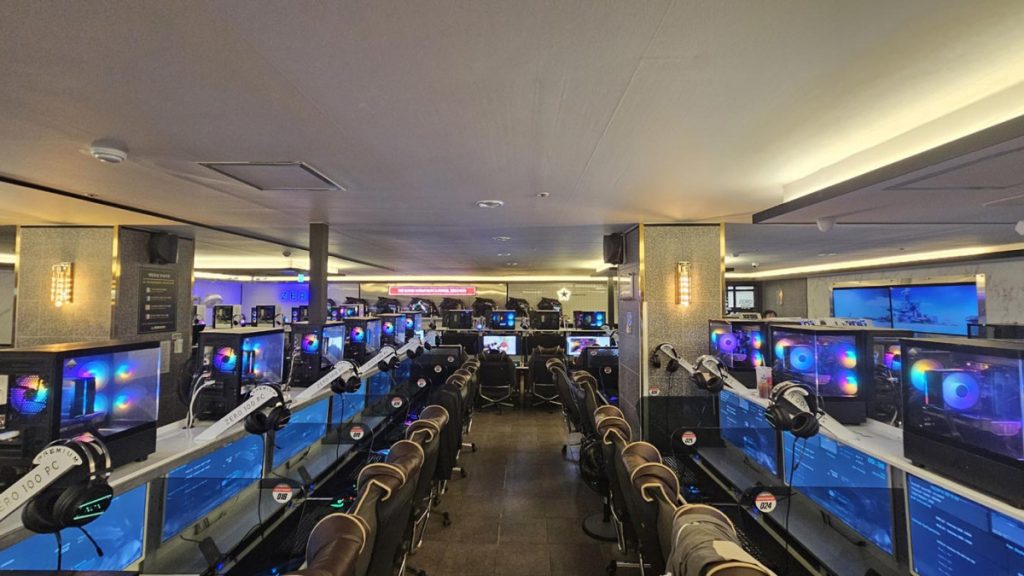 Interior of a modern Korean PC bang gaming café with rows of gaming computers.