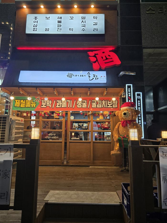 Traditional Korean pub signboards lighting up a lively night street.
