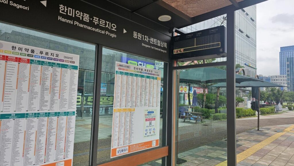 An electronic smart bus information system (BIS) display showing real-time arrival schedules and remaining minutes at a Korean bus station.