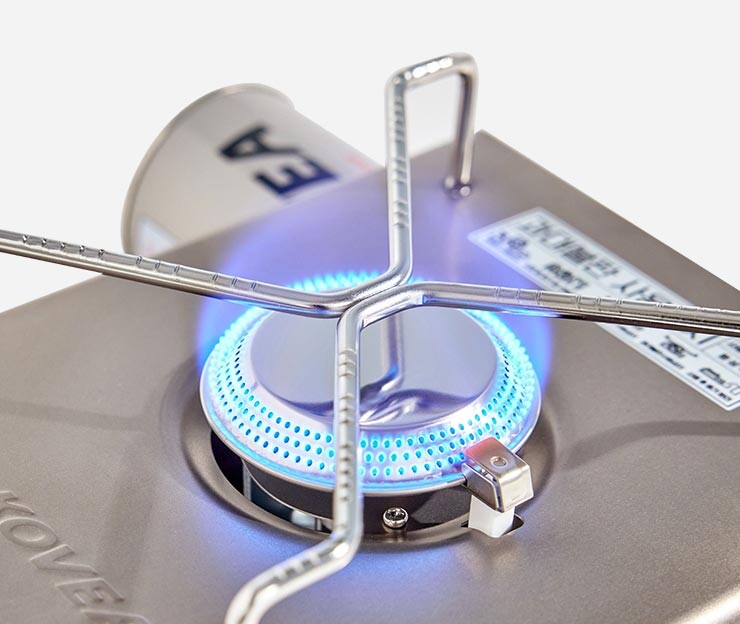 The powerful blue flame of the Kovea Titan Cube camping stove, demonstrating its high heat output and wind resistance.