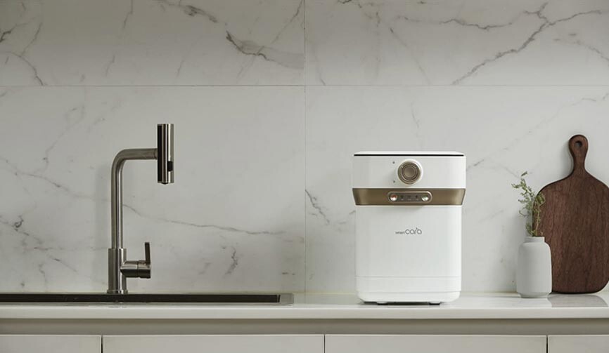 The compact Smartcara 400 Pro X conveniently placed right next to the kitchen sink for easy food waste management.