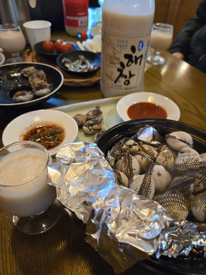 Makgeolli served with shellfish, a popular Korean pub food pairing.