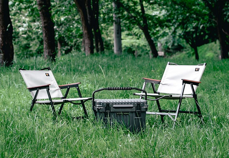 Minimal Works Life Folding Chair B Plus Review set up on green grass at a campsite