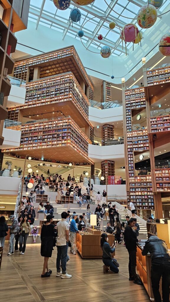 The grand, multi-story Starfield Library at Starfield Suwon mall, showcasing its iconic towering bookshelves.