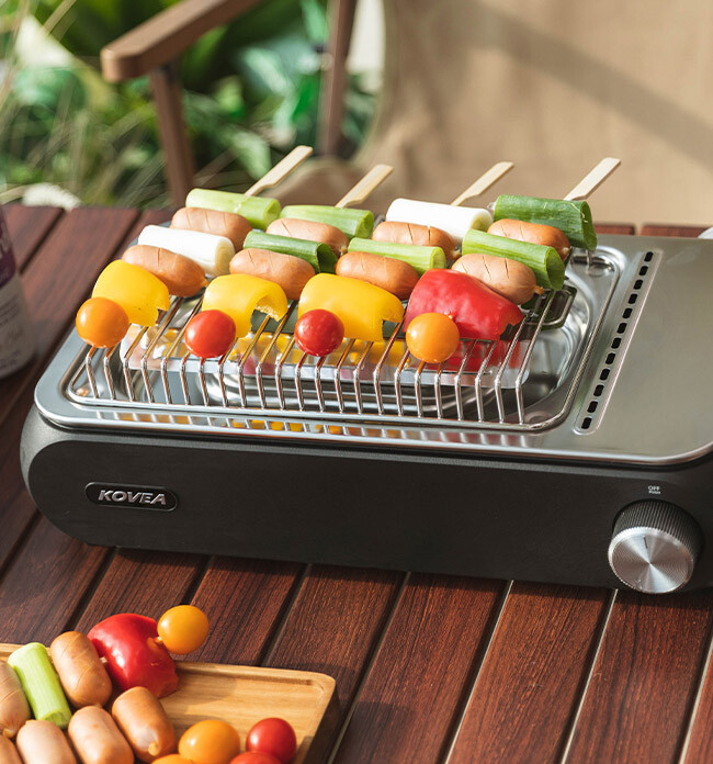 Delicious camping food skewers grilling on the stainless steel BBQ rack option of KOVEA Guibada.