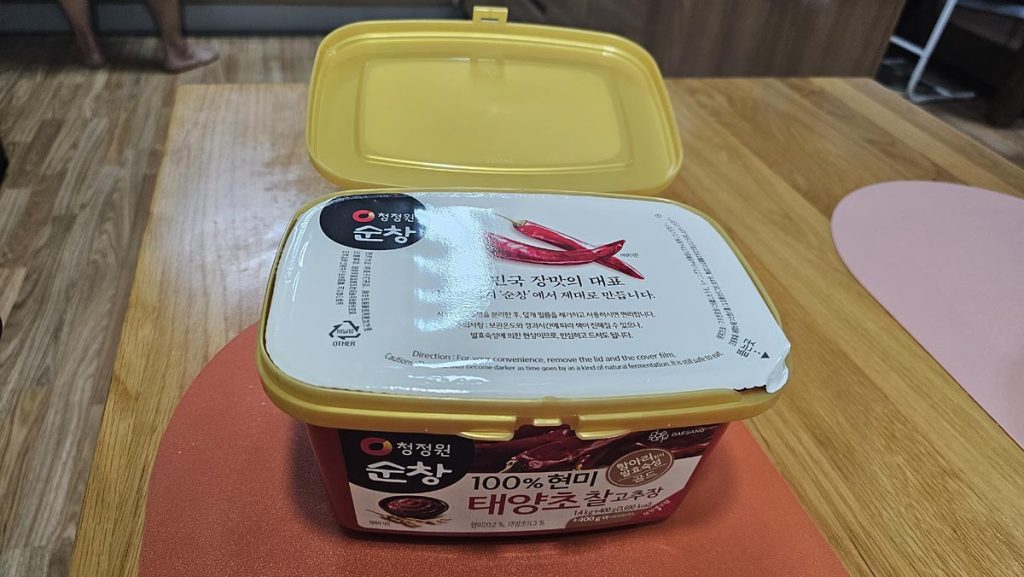 Chung Jung One Sunchang gochujang container with the inner seal before opening