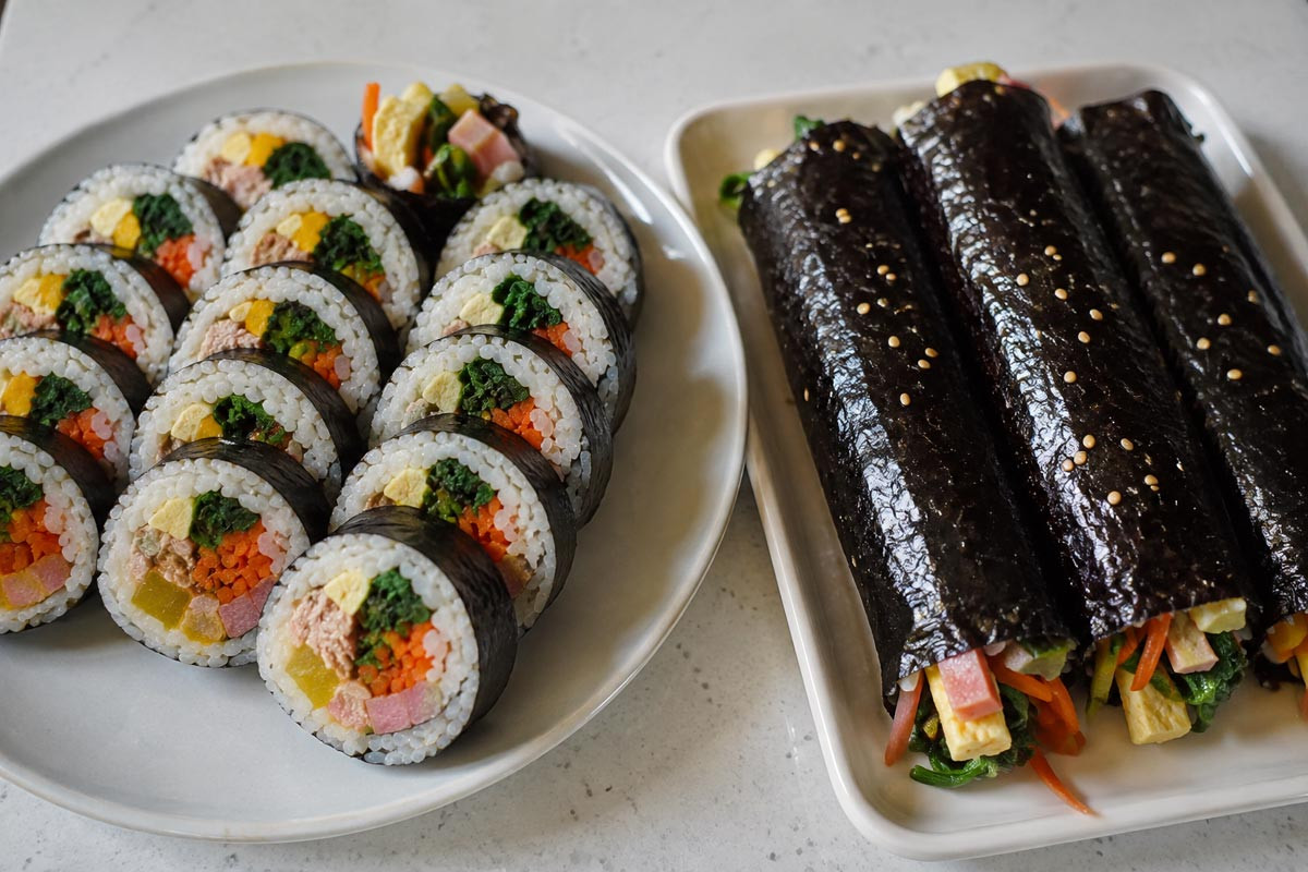 Homemade Korean kimbap filled with egg, vegetables, ham, tuna, and pickled radish