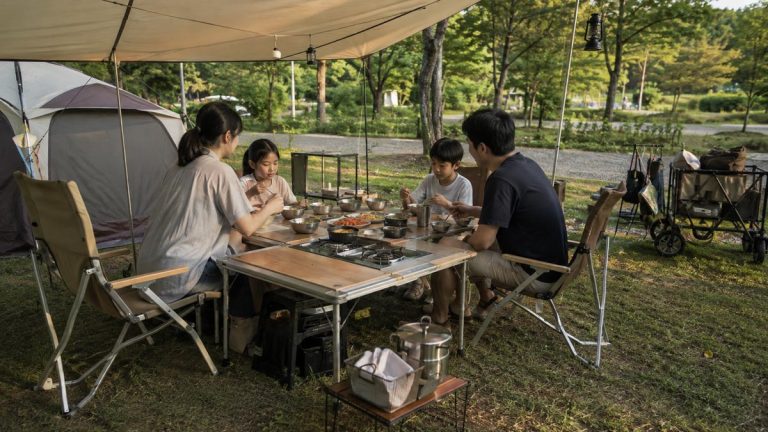 Korean family sharing a summer campsite meal around a modular IGT camping table