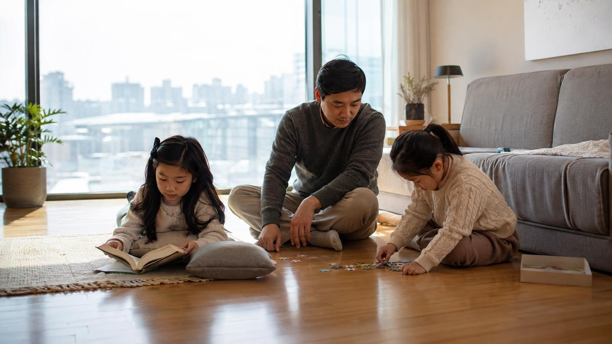 Korean family relaxing together on a warm floor heated by Korean floor heating in a modern apartment