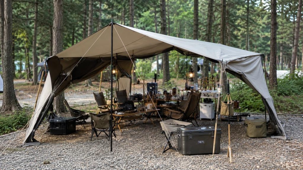 Korean floorless shelter camping setup with chairs, tables, lanterns, and camping gear arranged on a forest campsite