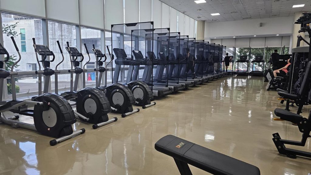 Rows of treadmills in a modern Korean gym cardio area