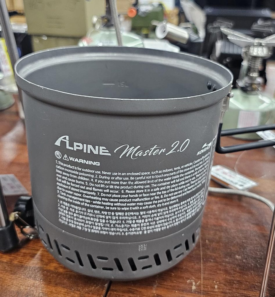 K-papa inspecting the size and exterior finish of the KOVEA Alpine Master 2.0 camping cooking system in person