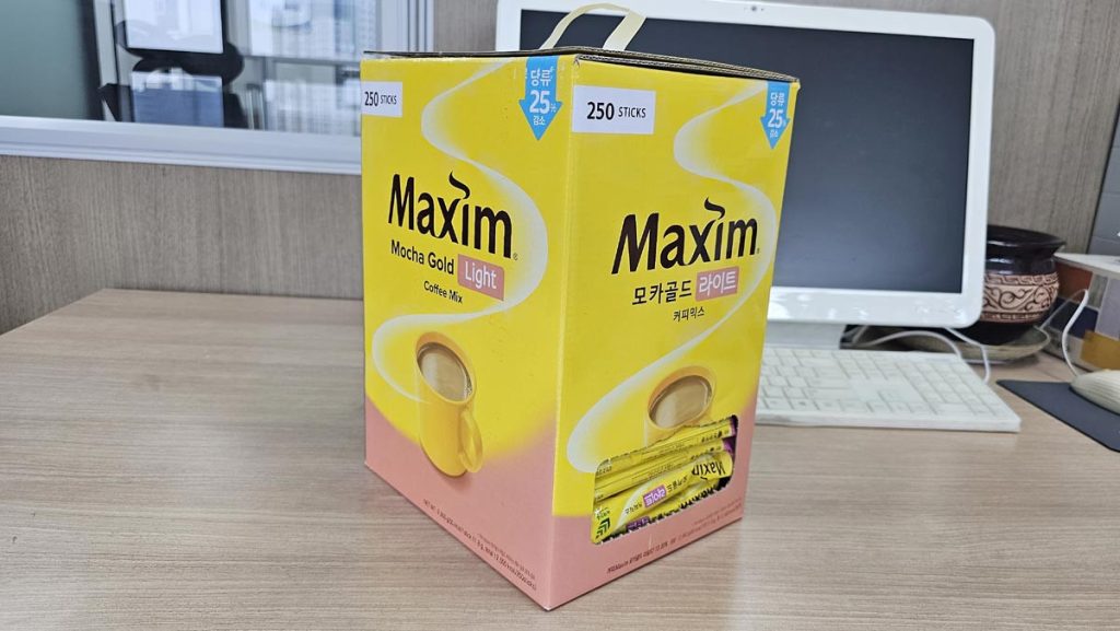A 250-stick box of Maxim Mocha Gold Light coffee mix on an office desk