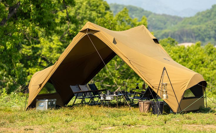 Minimal Works Superposition shelter arranged as a spacious outdoor living area at a campsite