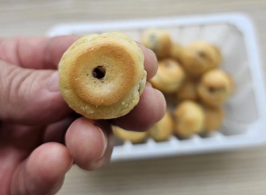 Close-up of a single round Haitai Homerun Ball chocolate-filled pastry held by hand