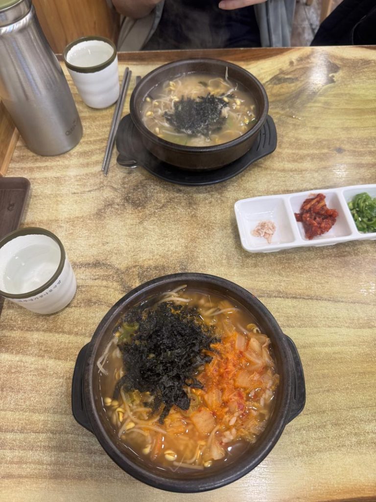 Two bowls of Korean kongnamul gukbap with bean sprouts, kimchi, and dried seaweed.