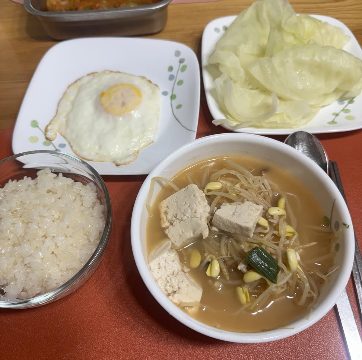 Korean home-cooked meals can be simple, with rice, soybean sprout soup, a fried egg, and boiled cabbage.