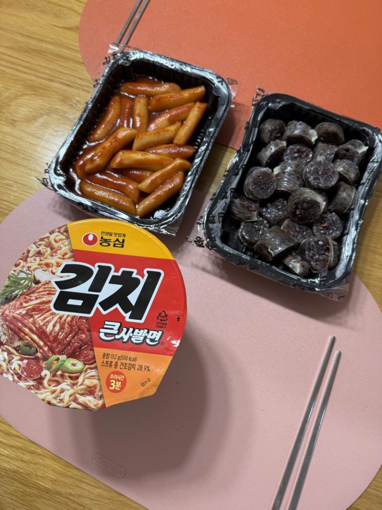 Delivered Korean tteokbokki and sliced sundae blood sausage served with a cup of kimchi noodles